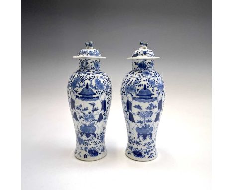 A pair of Chinese porcelain blue and white baluster vases and covers, late 19th century, each surmounted by a dog of fo above