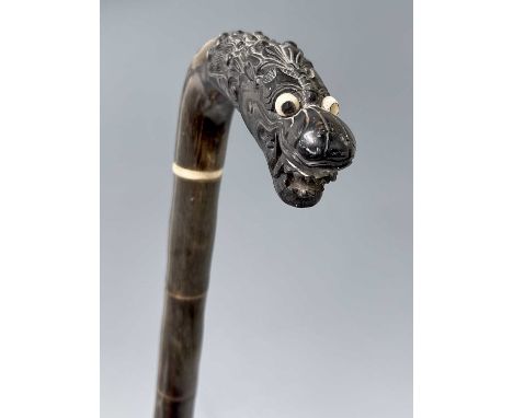 A Chinese horn walking stick, 19th century, with a carved dragon head handle, length 85cm, length of handle 12cm.Condition re