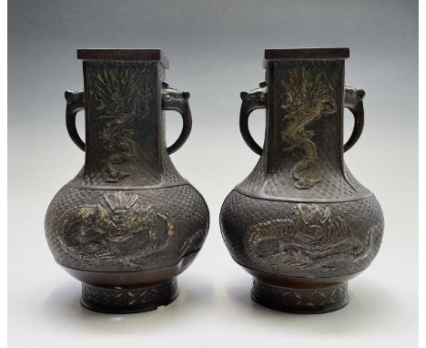 A pair of Chinese bronze vases, 18th/19th century, each decorated with stylised dragons, drilled seal mark to base, height 33
