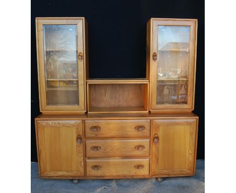 Ercol sideboard cabinet with central open shelf flanked by glazed doors, rectangular top, three long drawers flanked by doors