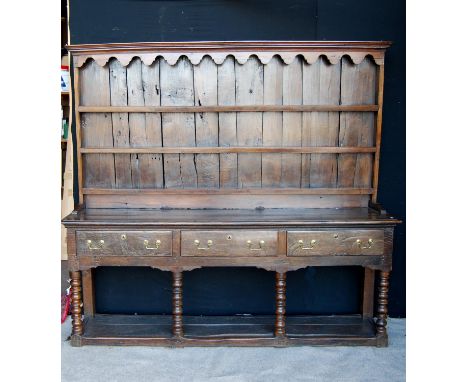 19th century oak dresser with projected moulded cornice over arched apron, open shelves, moulded rectangular top, three beade