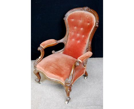 Victorian button-back armchair with floral carved wood frame, cushion back and seat, raised on cabriole legs terminating in c