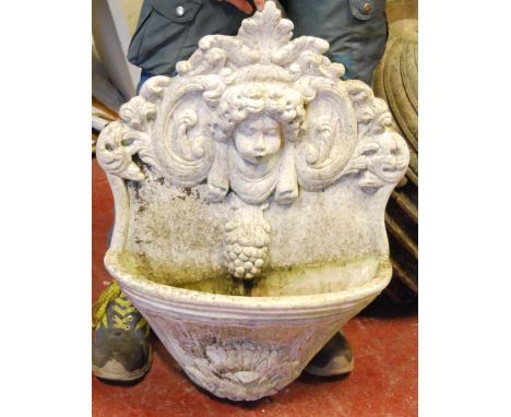 Composite wall fountain with floral back plate and cherub masks over basin, 56cm wide and 74cm high; together with a lion mas