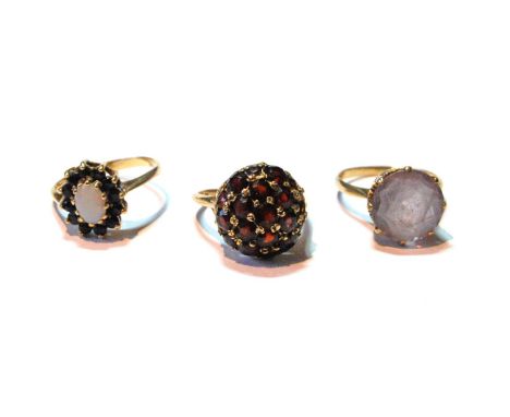 Garnet ring, another, rose quartz, and a sapphire and opal cluster ring, all 9ct gold. 
