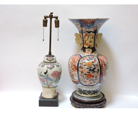 A 19th century Imari vase, a carved hardwood stand, and a famille rose jar, converted to a lamp