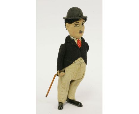 A Schuco Charlie Chaplin tinplate clockwork figure, in a black felt jacket with grey trousers and revolving tinplate walking 