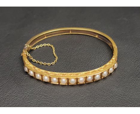 PEARL SET UNMARKED HIGH CARAT GOLD BANGLElate 19th/early 20th century, the bangle with engraved scroll decoration to the side