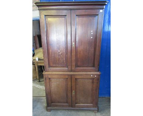 19th century Welsh oak two-stage cupboard, the geometric moulded cornice above two blind panel fielded doors, the interior re