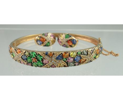 A 14ct gold multi gemset bangle and matching earrings. Set with yellow,blue,pink,orange and pale green sapphires together wit