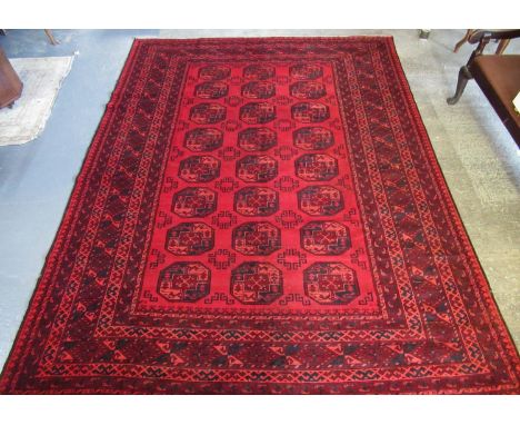 Red ground Afghan double knot carpet with traditional bokhara design. 335 x 258cm approximately.(B.P. 21% + VAT) 