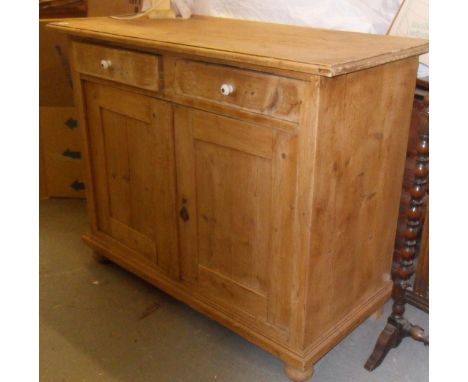 Pine dresser base having two drawers with ceramic knobs over two cupboard doors
