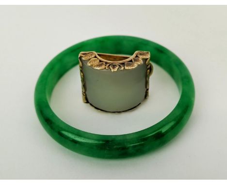 A JADE BANGLE, 47.96 grams, 7.5cm diam, plus a white jade silver gilt scarf clip, 29.2 grams. (2) 