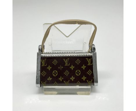 Metal butane lighter created to mimic a Louis Vuitton purse. Unmarked Issued: 20th centuryDimensions: 2"L x 0.50"W x 1.5"HCon