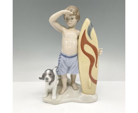 Adorable glossy figure standing looking out to the water with his dog. Lladro backstamp. This item has its original box: 12"L