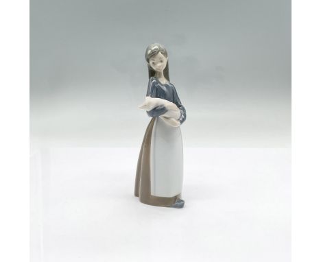 Glossy figurine of a girl gently holding a pig. This item has its original box which measures 8"L x 4"W x 3.25"H as well as i