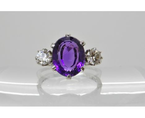 An 18ct white gold amethyst and diamond three stone ring. Amethyst approx 10mm x 8mm x 6.1mm. Diamonds estimated approx 0.40c