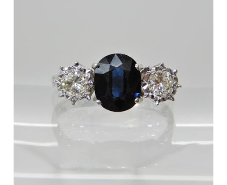 An 18ct white gold sapphire and diamond three stone ring sapphire approx 7.8mm x 6.3mm x 3.3mm, diamonds estimated approx 0.3