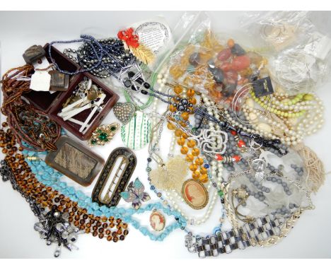 A large collection of costume jewellery to include a retro style pendant by Avon, a large vintage leaf designed buckle Condit