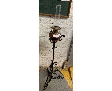 Oil lamp on wrought iron floor standing base