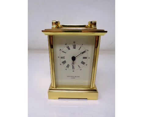 A heavy brass cased battery operated mantel clock by Taylor &amp; Bligh of London (height 15cm).