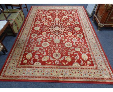 A machine made woolen Persian design carpet on red ground, 288cm by 201cm