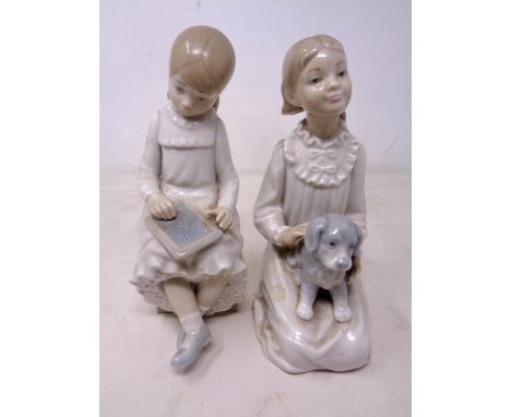 Two Nao figures, girl seated writing on a slate and girl kneeling with puppy.