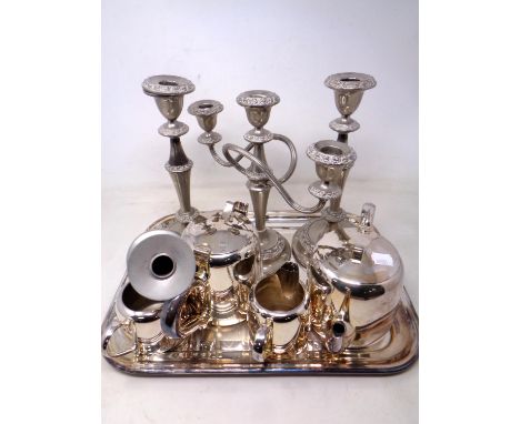 A four piece S Heart &amp; Co plated tea service on tray together with a pair of plated candlesticks with matching three-way 