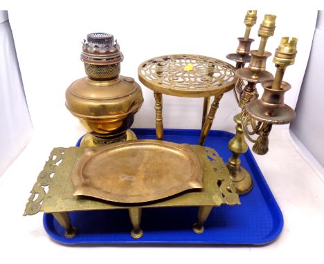 A tray containing antique and later brass ware including trivets, Art Deco tray, Famos oil lamp together with a three way can