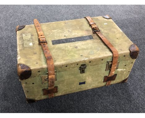 A vintage canvas shipping trunk with leather straps.