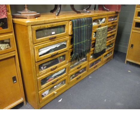 A bank of light oak Haberdashers shop display drawers of counter height, 94 x 182 x 54cm  