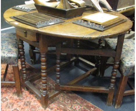 An early 18th century oak gateleg table on bobbin turned and joined legs  