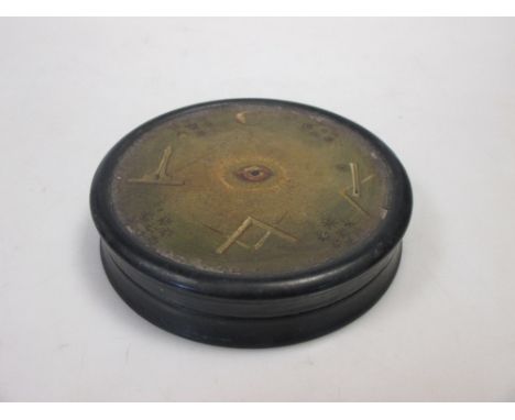 A 19th century papier mache snuff box, the circular lid with masonic symbols  