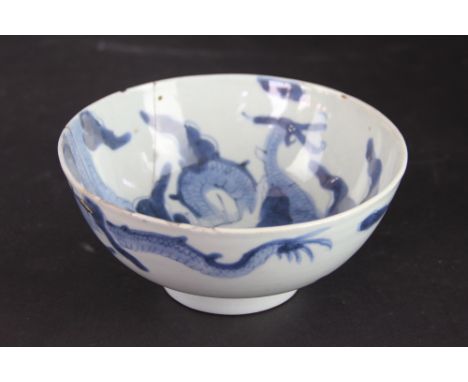 A Chinese blue and white bowl, Qing, decorated to the exterior and interior with a dragon chasing a flaming pearl amongst a c