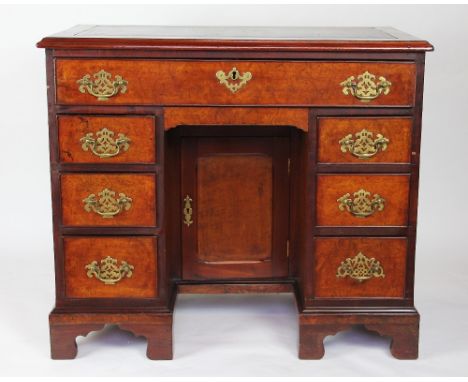 A 19th century mahogany and burr walnut kneehole desk, the leather inset top above a central drawer and two pedestals of thre