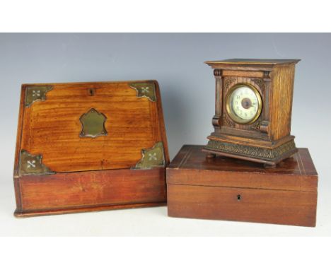 A Victorian oak stationary box, circa 1880, the canted front enclosing compartmented interior and writing slop, cover engrave