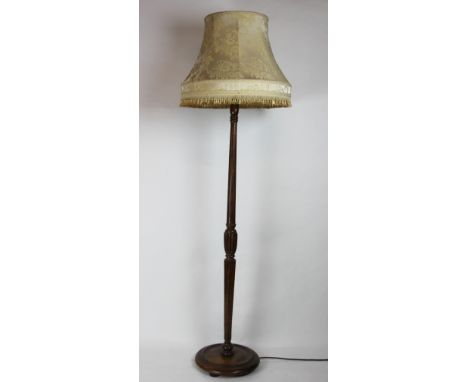 A stained beech standard lamp, with fluted column, on circular base, 164cm, with a shade. These are sold as decorative items 