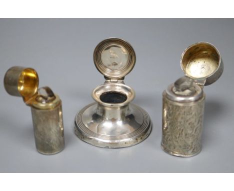 A silver capstan inkwell and two silver-cased cylindrical scent bottles with hinged lids, the larger foliate-engraved, the sm