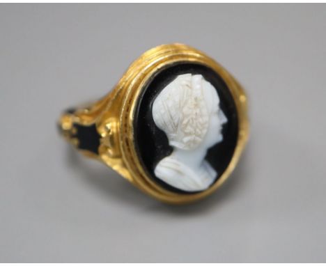 A Victorian 18ct gold cameo ring, of carved scrolled design with black enamelled decoration and hairwork panel, size M/N, gro