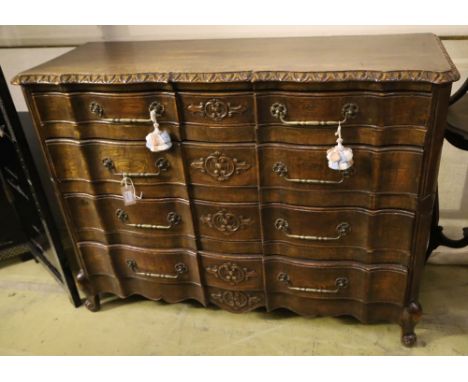 A 20th century French oak commode, fitted four long drawers with carved decoration, width 122cm, depth 43cm, height 92cm