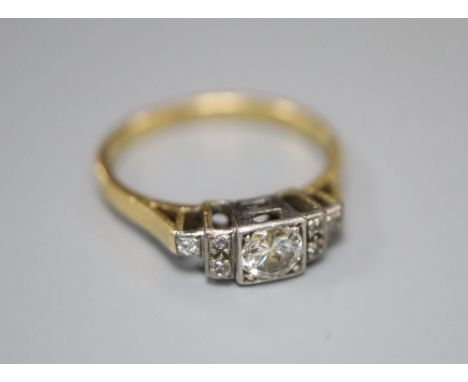 An early 20th century '18ct and plat' diamond ring, the square set central stone flanked each side by three further diamonds,