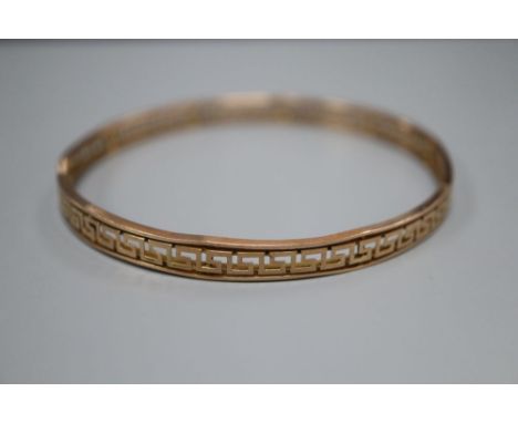 A 9ct bangle with pierced Greek key border, 12.8 grams.