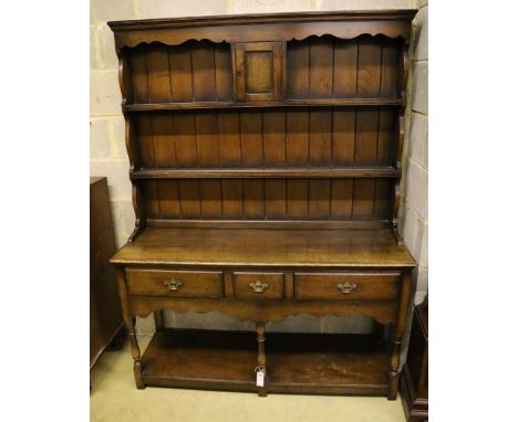 A small Georgian style reproduction oak dresser, having shelved boarded back, shaped apron and pot shelf, width 137cm, depth 