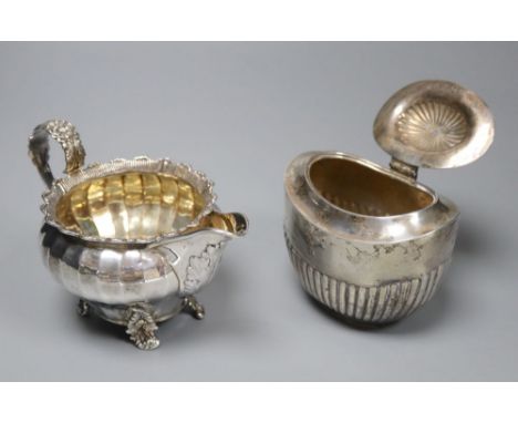 A George IV silver cream jug, London 1823 and an oval half-fluted tea caddy, William Hutton &amp; Sons Ltd, London 1897 (ebon