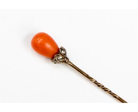 A Victorian coral and diamond set  yellow metal stick pin, the pear shaped coral mount above rose cut diamond collar, length 