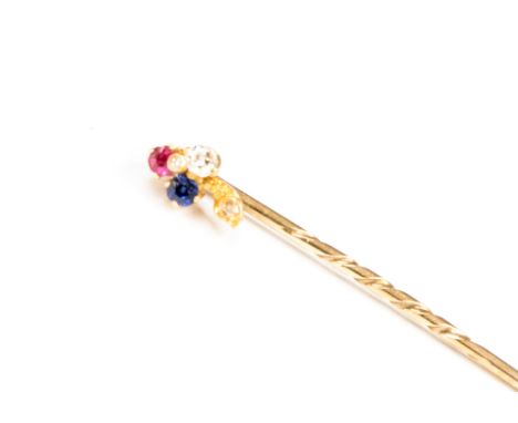 A diamond, ruby and sapphire yellow metal stick pin, the trefoil design head formed of an old mine cut claw set diamond, a mi