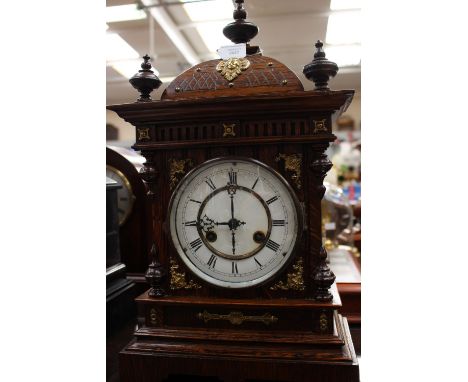 An early 20th century German mantle clock, J. Unghans, white enamel dial, black Roman numerals, brass inner chapter dial, oak