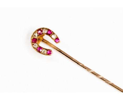 A Victorian diamond and ruby set horseshoe yellow metal stick pin, alteranating rose cut diamonds and mixed cut rubies