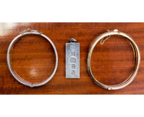 An Elizabeth II silver pendant ingot, Birmingham 1977, a silver bangle and a 9ct gold metal core bangle, silver weight 45 gra
