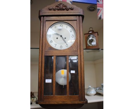 An early 20th Century oak eight day wall clock, together with a small mahogany cased bracket clock (2)