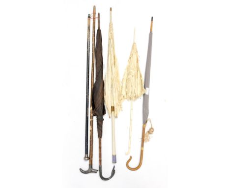 A collection of parasols and men's walking sticks to include a silk 1890s parasol, with an ivory handle, a bamboo 1930s umbre